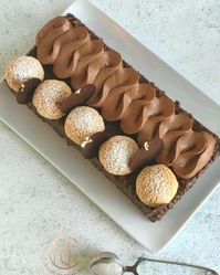 Ce gâteau ultra gourmand est à la fois moelleux, fondant et croustillant !! Il est composé d’un moelleux au chocolat recouvert d’un glaçage rocher le tout surmonté de quelques choux craquelin fourré d’une onctueuse crème pâtissière. Et pour un peu plus de gourmandise, j’ai ajouté une ganache montée au chocolait. Ce gâteau en forme de buche est tout simplement idéal pour accompagner vos repas festifs! Et il fera de l’effet auprès de vos convives.