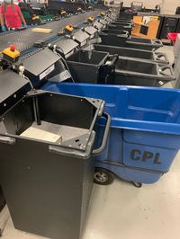 TechLogic sorter at Chicago Public with a combination of bins (e.g. black standard bins in foreground), big moveable trolleys (blue CPL trolley), SmartBins (third position) and totes (not seen in this picture