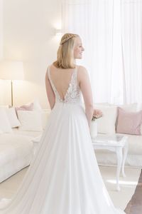 Mit seinem Elisa Spitzenoberteil fließt das wunderschöne Oberteil dezent in den Chiffonrock, welcher fließend zu Boden fällt und verleiht dem Design einen eleganten und sommerlichen Charme. Die klassische A-Linie eignet sich perfekt für deine Hochzeit im Frühling, Sommer oder Herbst. All unsere Brautkleider - auch unser Design Elisa - kannst du in deiner Anprobe bei uns individuell mitgestalten und miteinander kombinieren, so dass du dein ganz persönliches Traumkleid finden kannst.