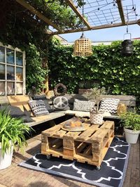une table basse exterieur à roulettes d'aspect brut réalisée avec deux palettes superposées, salon de jardin réalisé entièrement en palettes