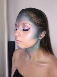 If scales feel too advanced, this half-mermaid, half-avatar vibe, created by makeup artist Becca Geary (@beccagearymakeup), is slightly more simple. Geary blended blue shadows around her face, neck, and—yes—ears. It's one of the most important steps for making the look appear realistic, she says.