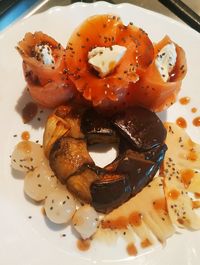 Cuore di melanzane con salmone affumicato e formaggio accompagnati da cipolline e bambù in salsa poke