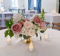 Lush garden style centerpieces of neutral, blush, and pink garden roses, ranunculus, snap dragon and fresh greenery by Leaf + Petal NOLA for a wedding at Il Mercato in New Orleans