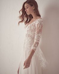 Allow us to introduce you to this ethereal lace A-line wedding gown! From the bell sleeves to the sexy thigh high slit....what is not to love?! Click through for all the deets! #A-lineweddinggown #bellsleevebridaldress #laceweddingdress #Maggiesottero