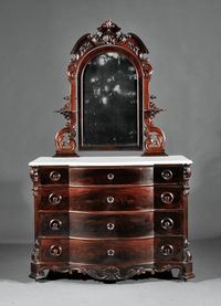 American Rococo Carved Mahogany Dressing Bureau, Arched Mirror Within Conforming Support With Candle Shelves And Scrolls, Base With Shaped Marble Top, Four Drawers, Chamfered Lappet Stiles, Blocked Feet, Casters c. Mid 19th Century