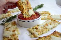 These cheesy cauliflower breadsticks are baked with fresh rosemary and just smell divine whilst baking. If the smell cannot tempt you, the low carbs of 1g net carb per stick will! #divaliciousrecipes #cauliflower #keto #lowcarb #grainfree