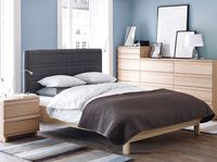 Dormitorio con cómoda, mesilla de noche y cama OPPLAND en roble claro.