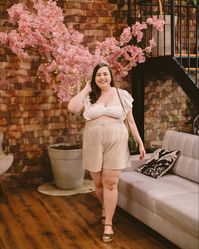Look plus size usando cropped off white manga babados farm e short de linho neutro cru sandália salto bloco laranja cinderela de mentira