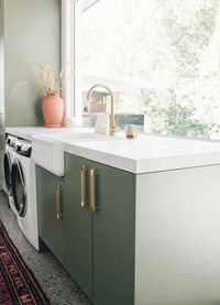 Celebrating the greenery that surrounds this beautiful contemporary home, is a soft sage draped over laundry cabinetry. 🌱 Making laundry day a dream is @cedarandsuede 's light-filled space that has completely changed the way we think about washing clothes. Has your laundry's style made doing laundry more enjoyable? 🙌