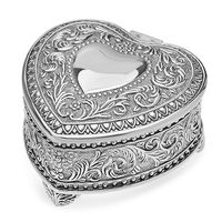 This vintage charming heart shaped jewelry box features an intricately carved exterior with a smooth, polished heart shaped center. It opens with a hinged lid that's lined on the interior with dark blue cloth, giving it a warm, luxurious look. It is balanced on three feet attached to the heart box's base.
