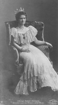 Grand Duchess Eleonore of Hesse and by Rhine, wears turn-of-the-century dress with a sweetheart neckline framed by modesty piece and wide lace bertha in this Elbert photo