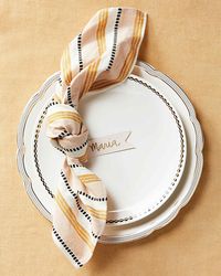 Pair a loosely knotted napkin with a handwritten place card. It's the perfect place setting for an elegant Thanksgiving table.