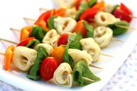 Simple yet appealing! Stop light peppers, cheese tortellini, basil leaves and grape tomatoes on a skewer! Drizzle with Italian dressing or basil pesto. Me, I'd add a sprinkle of parmesan cheese, some cracked pepper and call it a day.
