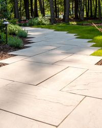 This walkway design is inspired by our Aberdeen slab. Versatile in its landscaping design, the Aberdeen slab can look traditional by installing it in modular patterns, integrating all its sizes. You can also achieve a contemporary look by having it installed in linear patterns. Check out our website to shop the look! Or, check out the estimation tool on our website to get an idea of how much a similar project could cost you!