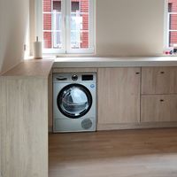 Cocina a medida con acabados claros y revestimiento efecto madera