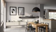 The wall-mounted living room solution, in Dove Grey matt lacquered finish, plays on the chromatic continuity with the Evolution kitchen, defining a harmonious dining area where the table and chairs liaise harmoniously with the adjoining space.