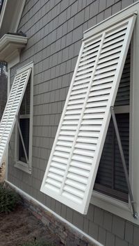White bahama style exterior shutters by The Louver Shop