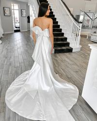 Say "hello," to this unabashedly chic and feminine bridal gown! This unique strapless satin mermaid wedding gown is right for you if you are looking for a classy statement. Just look at that optional bow! 😍 Click through for all the deets! #satinweddingdress #mermaidbridalgown #Mitchellmaggiesottero #statementbow #maggiesottero