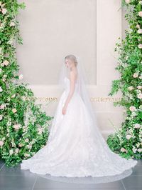 Leaf + Petal created a dramatic ceremony setup for a New Orleans garden wedding at New Orleans Museum of Art. With blush, peach, and neutral garden roses, ranunculus, delphinium, and lush overgrown greenery, the setup beautifully framed the couple as they exchanged vows.