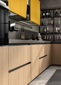 Mustard Yellow matt lacquered wall units with slanted door, combined with Anthracite coloured metal open-fronted wall units, choices whose value is generously emphasised by the combination with the Wheat Oak veneered fnish of the composition.
