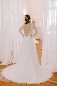 Romy verzaubert durch einen tiefen Rückenausschnitt, spitzenbesetzten Ärmelchen und einem aufregenden Dekolleté. Vollendet wird das Design durch eine zarte Schleppe, die sicherlich für einen Hingucker sorgt. Die klassische A-Linie eignet sich durch die langen Arme perfekt für eine Winterhochzeit. All unsere Brautkleider - auch unser Design Romy - kannst du in deiner Anprobe bei uns individuell mitgestalten und miteinander kombinieren, so dass du dein ganz persönliches Traumkleid finden kannst.