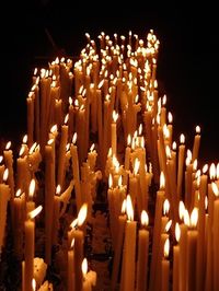 In her place 100 candles burning, as salty sweat drips from her breast. Her hips move and I can hear what they're saying. Swaying. They say the beast inside of me is gonna get ya, get ya yeah.