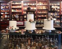Leaf + Petal added lush garden florals, including garden roses and ranunculus, to three simple wedding cakes for a wedding at the Pharmacy Museum in New Orleans.