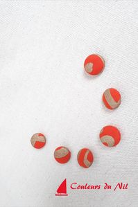 Du dynamisme et du chic avec ces boutons (en deux tailles différentes) orange. Avec une petite épingle, un gros bouton fera une très jolie broche. Suivre le lien pour retrouver les boutons. Sur la page des boutons, vous trouverez le lien pour le tissu orange et doré.