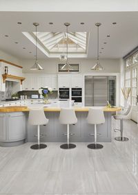 Our Designers moved the kitchen into the generously sized orangery space, with informal seating around a breakfast bar. Creating a bright, welcoming, and social environment to prepare family meals and relax together in close proximity. In the warmer months the French doors, positioned within this kitchen zone, open out to a comfortable outdoor living space where the family can enjoy a chilled glass of wine and a BBQ on a cool summers evening.