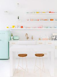 white kitchen with mint green smeg refrigerator and colroful dishware on open shelves / sfgirlbybay