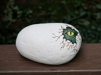 I painted this rock to look like a baby dinosaur peeking out of a broken eggshell. Cute in the garden or in a plant pot. Or, even on your son or daughters dresser. Rock painted by Lori Hum-McDade.