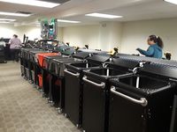 Standard TechLogic bins and totes on TechLogic sorter - print and apply machine on top applies Hold slips