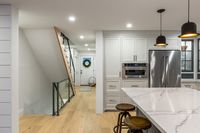 This modern farmhouse inspired space is home to a busy family of four. The goal of this renovation was a cozy, family friendly space to gather and entertain. The spacious custom kitchen and open dining area were key to ensuring that everyone could gather together. Ship lap walls, patterned backsplash and the reclaimed wood table all work together to create a warm and inviting space. Custom draperies and furniture complete this charming family home.