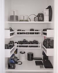 Coat closet turned photography equipment storage. Shelves added, $3 spice racks from Ikea serve as storage for lenses and other gear.