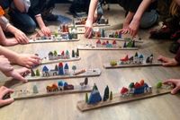 Sculpture de maisons collées sur une planche en bois.