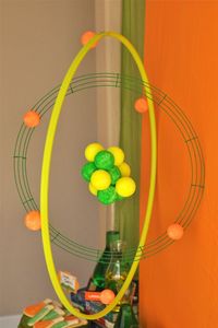 Science party decor: large scale atom using a hula-hoop, wire wreath, paint, and styrofoam balls.