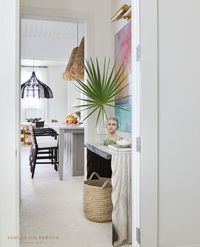 ASHLEY GILBREATH INTERIOR DESIGN: A simply stunning vignette between the Alys Beach contemporary style kitchen and functional laundry room. This small space makes for the perfect place to display the client's original art collection illuminated by a brass picture light. architect Gary Justiss