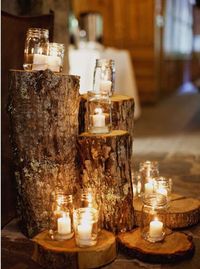 Candles in mason jars on firewood.