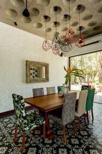 A dimpled concrete ceiling sits atop the dining space. Image courtesy, The Orange Lane