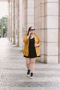 Look plus size com vestido preto e blazer mostarda estampado cinderela de mentira ana luiza palhares