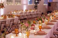 Bright and colorful garden style compote centerpieces line a guest table at a wedding reception at Il Mercato in New Orleans. Florals by Leaf + Petal NOLA