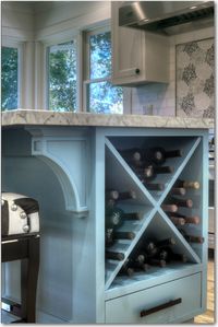 Wine Storage. Large transitional u-shaped light wood floor kitchen with a farmhouse sink, white cabinets, white backsplash, stainless steel appliances, an island, recessed-panel cabinets, granite countertops and ceramic backsplash. #mixedcabinets #kitchendesign #traditionalkitchen #traditionaldesign #luxe #glamkitchen #whitecabinets #farmsink #farmhousesink #kitchenchandelier #islandchandelier #islandlighting #blackcountertops #tuxedokitchen
