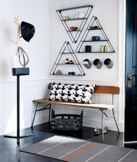 Storage is important in the entryway. This is where you will be dropping off your coats, bags and shoes. Utilise the walls with trendy metal shelves, sleek coat hangers and storage baskets. Image courtesy, CB2