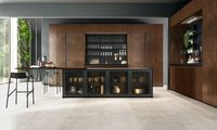 Base cabinets fronts: Heat treated madera oak and black aluminum frame smoked glass | tall cabinets fronts and above columns: Copper oxidized liquid metal | Snack table: Heat treated madera oak | Worktop: Dekton | Groove and plinth: Urban