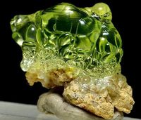 Unusual specimen of transparent botryoidal chalcedony var. hyalite on matrix, with unique daylight fluorescence in intense green color. credit: SpiriferMineral