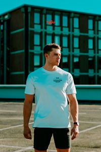 WEDAMNZ MERCHANDISE aesthetic men walking with a sunglass and a white creative shirt and text Poses for men, ideas, business, aesthetic, walking Creative photography ideas with a lot of color, orange and teal for a clothing brand Influencer, Instagram, content creator, content creative, creative photography Men fashion, men clothing styles, streetwear fashion
