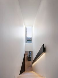 C.Kairouz Architects design a simple, light & bright staircase for the centre of this pair of Melbourne Townhouses. Highlight window, LED strip lighting on the black hand rail lead residents up & down this home. Warm timber treads combine nicely with white walls & black details. Click for more. #staircasedesign #modernhousedesign #interior #stair #timberfloors #LED #lights #windowdesign #window #view #staircaseideas
