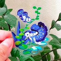 So Pretty! You'll love this highly detailed sticker featuring two half moon bettas with constellation accents, designed by our talented artist Thousand Skies! This transparent sticker is durable enough to last on cars, water bottles, laptops, notebooks, and other areas that receive a lot of wear and tear. Dishwasher safe and looks great on any surface! Main photo shows white border, but that's the removable backing - see second photo for transparency. :-) About this item: 3" x 2.4" Vinyl waterpr