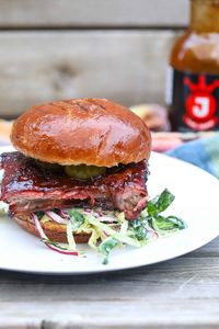 Make this delicious smoked rib sandwich! This is way better than a McRib. A thick slab of smoked spareribs topped with a collard greens slaw and pickles. #ribsandwich #ribs #porkribs #sandwich #smokedspareribs #mcrib #dinner #bbqrecipes