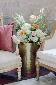 A gorgeous lounge space setup with lush toffee garden roses, ranunculus, and greenery for a wedding at Marigny Opera House in New Orleans. Garden flowers by Leaf + Petal NOLA, rentals by Lovegood Rentals.